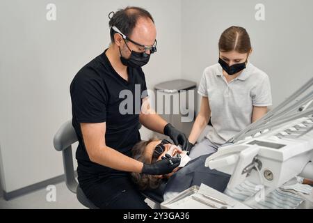 Dentist gives a lady an anesthetic injection with special syringe Stock Photo