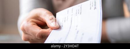 Hand giving paycheck, check, cheque in transaction concept Stock Photo