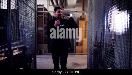 Male Security Guard Or Bodyguard Using Flashlight At Night Stock Photo