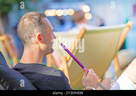 outdoor summer cinema with spectators and hookah on a sunny evening Stock Photo