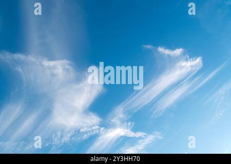 Wisps of high altitude Cirrus clouds (Mare's tails) against clear blue sky Stock Photo