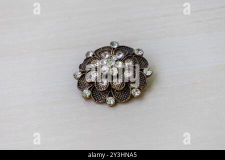 Beautiful brooch pin for women, crafted from shiny stones in the shape of a flower. This jewelry piece is worn as an adornment, often for aesthetic, c Stock Photo
