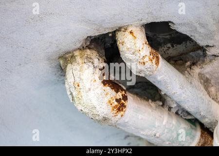 Rusted plumbing pipes on the roof used for water supply. Close-up of pipe for water line on building roof. Stock Photo