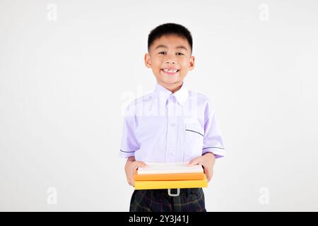 Portrait smile Asian little boy primary posing hand holding book studio isolated white background Stock Photo