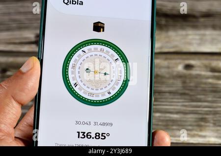 Cairo, Egypt, August 27 2024: Qibla direction towards Kaaba by a mobile smartphone application,  Qibla compass app used by Muslims to indicate the dir Stock Photo