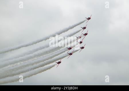 Nine Hawker Siddeley Hawk Jets of the British Royal Air Force Red Arrows aerobatic display team in delta formation and with smoke on at the RIAT Stock Photo