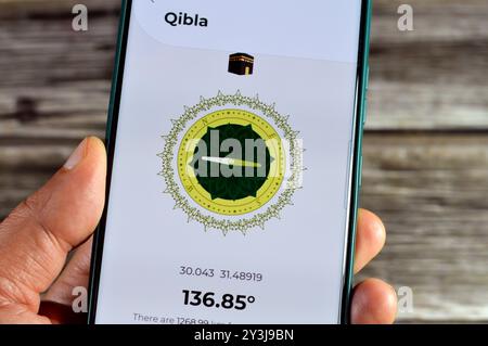 Cairo, Egypt, August 27 2024: Qibla direction towards Kaaba by a mobile smartphone application,  Qibla compass app used by Muslims to indicate the dir Stock Photo