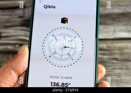 Cairo, Egypt, August 27 2024: Qibla direction towards Kaaba by a mobile smartphone application,  Qibla compass app used by Muslims to indicate the dir Stock Photo