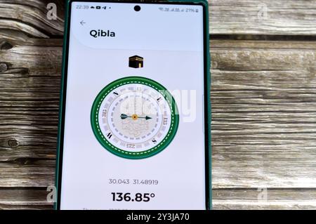 Cairo, Egypt, August 27 2024: Qibla direction towards Kaaba by a mobile smartphone application,  Qibla compass app used by Muslims to indicate the dir Stock Photo