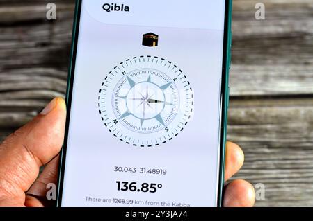 Cairo, Egypt, August 27 2024: Qibla direction towards Kaaba by a mobile smartphone application,  Qibla compass app used by Muslims to indicate the dir Stock Photo