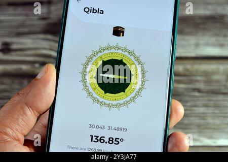 Cairo, Egypt, August 27 2024: Qibla direction towards Kaaba by a mobile smartphone application,  Qibla compass app used by Muslims to indicate the dir Stock Photo