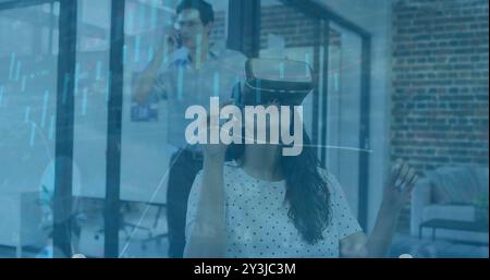 Using virtual reality headset, woman interacting with data visualization image Stock Photo