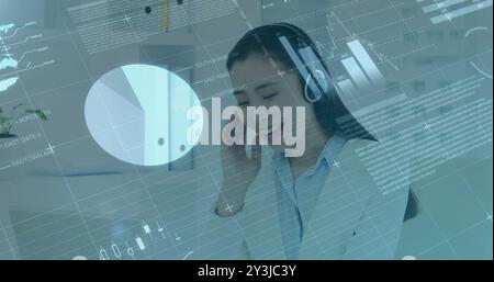 Image of financial data processing over asian businesswoman using phone headset and computer Stock Photo