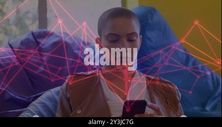 Image of network of connections over biracial woman using smartphone Stock Photo