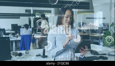 Image of financial data processing over biracial businesswoman using tablet in office Stock Photo