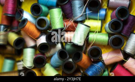 A variety of colorful spools of thread ready to be used for sewing and textile projects. Stock Photo