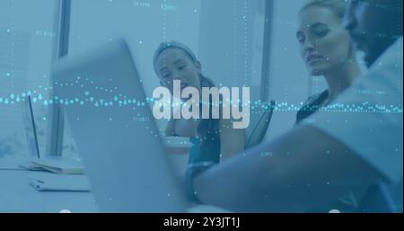Image of financial data processing over diverse business people using laptop Stock Photo