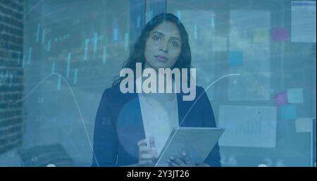 Image of financial data processing over biracial businesswoman in office Stock Photo
