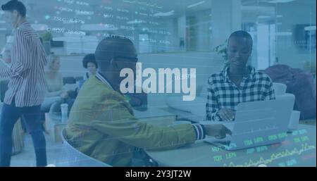 Image of financial data processing over diverse business people using laptop Stock Photo
