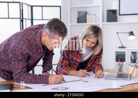 Architects making engineering drawing at wooden table in office Stock Photo