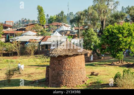 Traditional ethiopian stone round house with thatch and local village in the background, Lalibela, Amhara Region, Ethiopia. Stock Photo