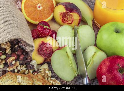 Fruits and nuts background with a mix of apples, oranges, bananas, peach, strawberries and different types of nuts, like walnuts, almonds, hazelnuts, Stock Photo
