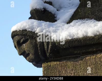 Close up of the carving of a womans face in profile on the corner of the ancient ruined medieval church in heptonstall west yorkshire covered in winte Stock Photo