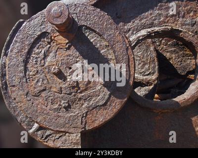 Corroded iron wheels covered in brown rust on old industrial machinery Stock Photo