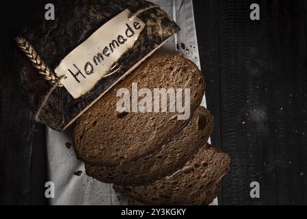 Sliced rye-bread on kitchen towel. German brown bread home-baked in low light Stock Photo