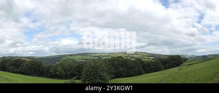 A wide panoramic view of the calder valley with the village of heptonstall and the towns of hebden bridge and mytholmroyd visible between forest trees Stock Photo