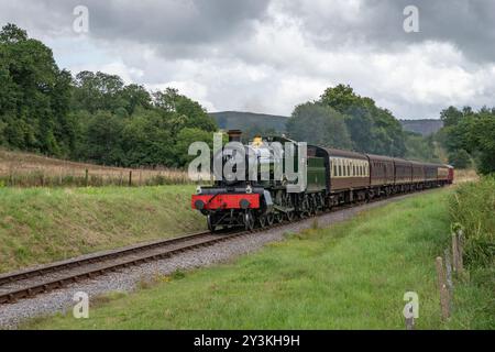 resident steam locomotive GWR 7800 Manor Class 7812 Erlestoke Manor approaches Leigh Wood Crossing on the West Somerset Railway Stock Photo