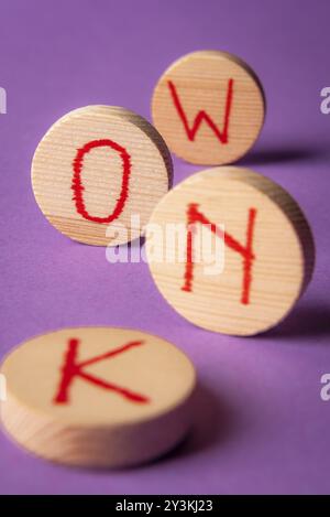 Know word written in red ink on round wood pieces, on a purple background. Knowledge concept. Know now Stock Photo