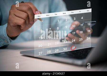 Close-up of a person using a digital calendar on a laptop, highlighting the date October 31st with a red circle, indicating planning or scheduling. Stock Photo