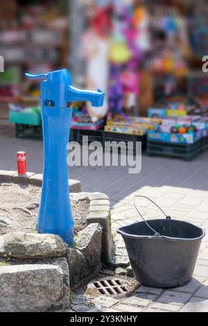 A blue water pump on a pedestrian street with a water pump next to it Stock Photo