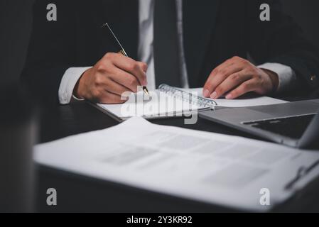 Businessman taking notes during meeting. Emphasis on planning, strategy. Suitable for business, office, project management. Stock Photo