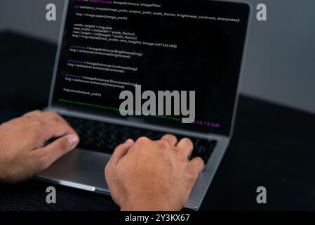 Close-up of a programmer's hands coding on a laptop. Highlights the software development process and coding environment. Suitable for tech articles, I Stock Photo