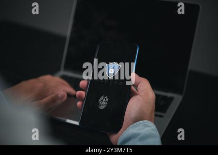 Person using smartphone with fingerprint authentication, ensuring digital security. Modern mobile technology for identity verification, data protectio Stock Photo
