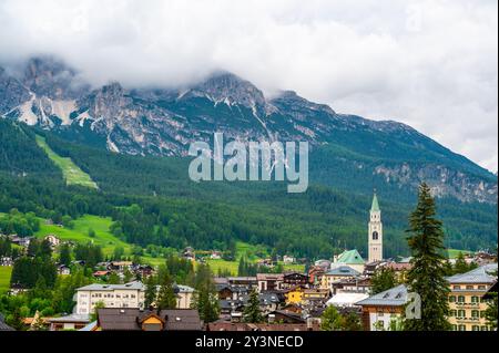 A panoramic view of the picturesque town of Cortina d'Ampezzo, nestled in the heart of the Dolomites. Majestic mountains rise in the background, offer Stock Photo