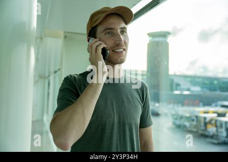 Traveler man at the airport with his smartphone waiting to get on his plane. Tourism, travel an destination concept Stock Photo