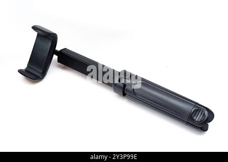 Universal tripod and selfie stick isolated on white background. Black plastic portable phone stick Stock Photo