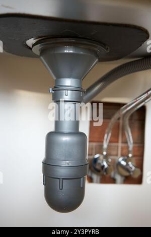 gray siphon pipe for water drains, connection of the siphon pipe under the sink Stock Photo