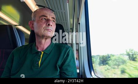 A man on a train. Older man commutes to work. Concept of daily routine of commute to work Stock Photo