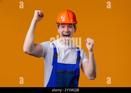 Mature worker man builder, triumph yes gesture of success. Excited handyman won Stock Photo