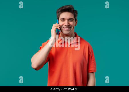Smiling positive man talking by phone, smiling. Mature guy on blue background. Stock Photo