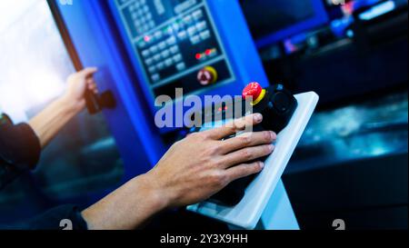 Worker hand controling cnc machine at workshop Stock Photo