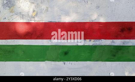 A green and red striped wall with a white stripe The wall is covered in graffiti. Stock Photo