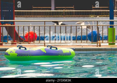 Inflatable green ring in swimming pool. Green ring swimming pool with handle float in blue clear water at sunny day Stock Photo