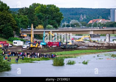 Excavators and trucks on the demolition site of the blasted section of the collapsed Carola Bridge, many spectators watching the work going on. Stock Photo