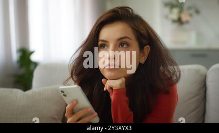 Bored thoughtful Caucasian female tired woman girl client user boredom typing message chatting using mobile phone scrolling social media boring online Stock Photo