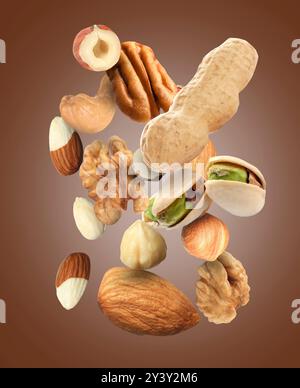 Pecan and other nuts in air on brown background Stock Photo